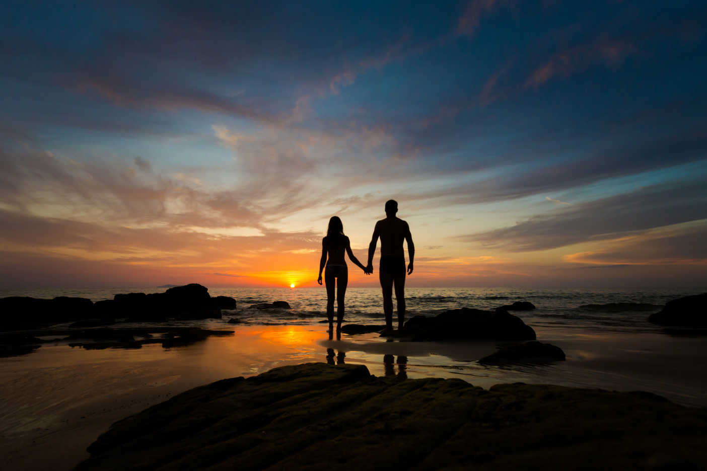 Couple walking toward the ocean