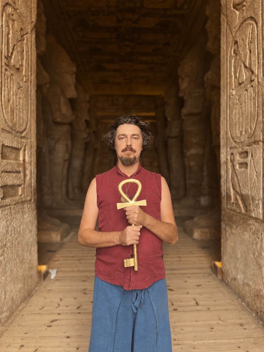 Kiya Ankara holding the golden Ankh key inside an ancient Egyptian temple corridor